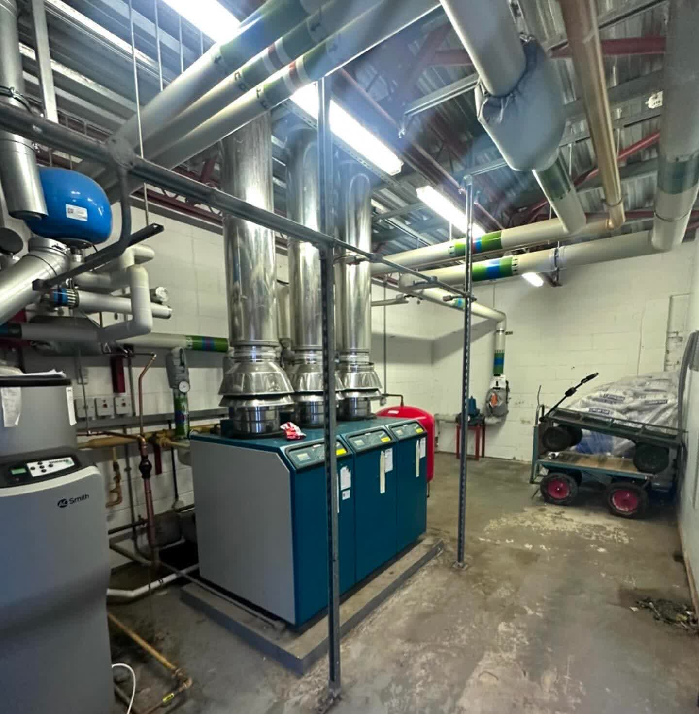 Portchester plant room before the rebuild: three ageing floor-standing boilers and cramped flues